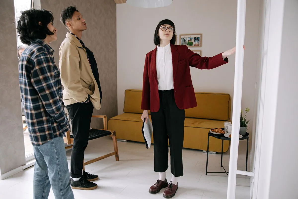 An agent showing a couple around a living room